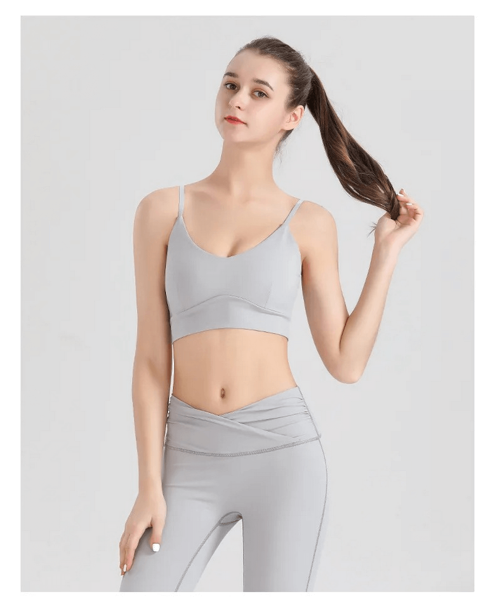 Woman wearing breathable spandex workout set, featuring a sleeveless top and leggings. Ideal for yoga and fitness. Solid light color design.